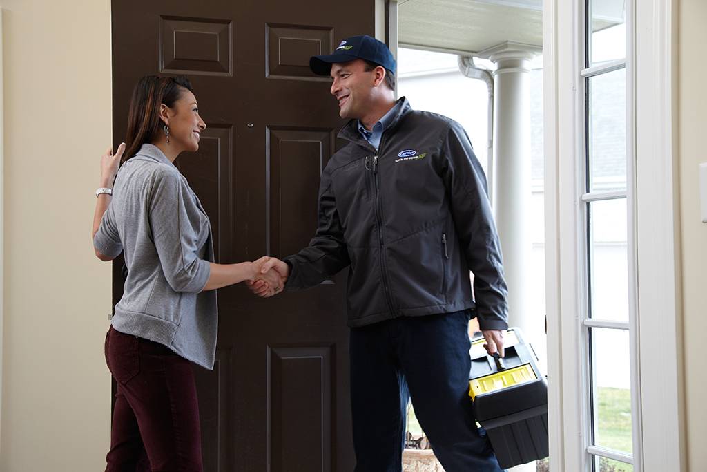 Carrier installation technician shaking hands with customer at door