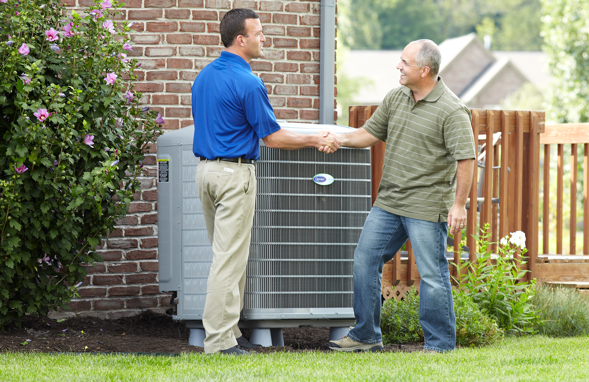 Carrier HVAC tech with customer outdoors
