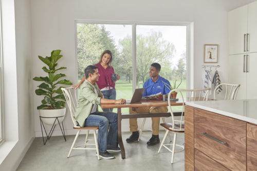 Couple with carrier sales rep in kitchen