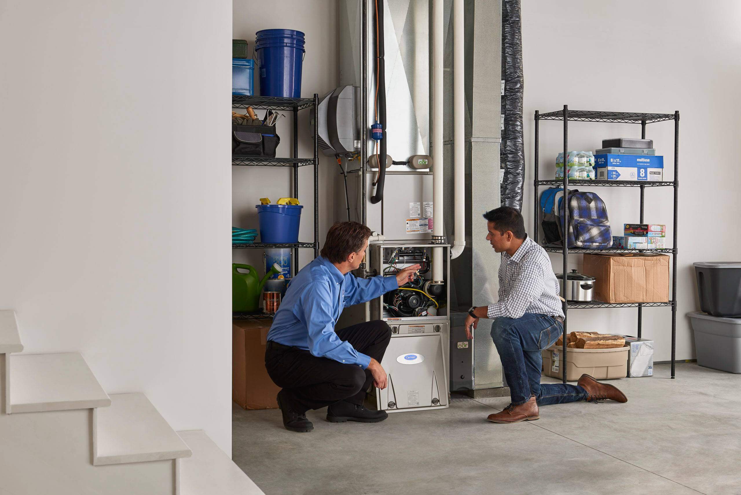 HVAC Tech repairing furnace with customer